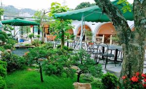 an outdoor patio with tables and chairs and umbrellas at Hotel Mountain View in Chinh Phú