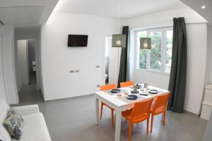 a dining room with a white table and orange chairs at Golden Beach Residence in Fregene