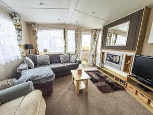 a living room with a couch and a television at Brilliant Caravan With A Partial Sea View In Suffolk Ref 32026Az in Lowestoft
