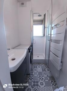 a white bathroom with a sink and a shower at T2 Vue latérale Mer 1 Ligne clim in Canet-en-Roussillon