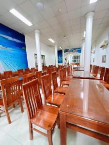 a dining room with wooden tables and chairs at Khách Sạn Mai Hà Sầm Sơn in Sầm Sơn +49 photos