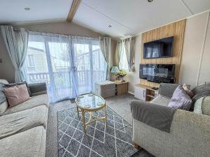 un salon avec deux canapés et une table dans l'établissement Beautiful Caravan For Hire With A Partial Sea View In Suffolk Ref 32042Az, à Lowestoft