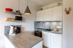 a kitchen with white cabinets and a counter top at Ferienwohnung BergChalet 1 mit Balkon in Braunlage +10 photos