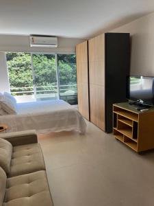 a bedroom with a bed and a flat screen tv at Flat em frente ao Allianz Parque in Sao Paulo