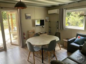 ein Wohnzimmer mit Tisch und Couch in der Unterkunft Chalet VIP Ostéa au coeur du Bassin d'Arcachon in La Teste-de-Buch