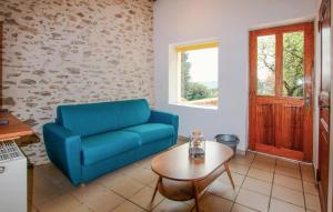 a living room with a blue couch and a table at Gorgeous Home In Piegon With Sauna in Piégon