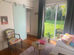 a living room with a couch and a chair and a window at IBI ENJOY la Suite in Ligné