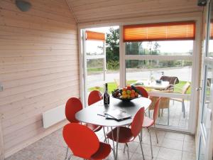 una sala da pranzo con sedie rosse e un tavolo con un cesto di frutta di Kattegat Strand Camping a Øster Hurup