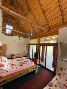 two beds in a room with wooden ceilings at NINO Natural wood house in Visoko