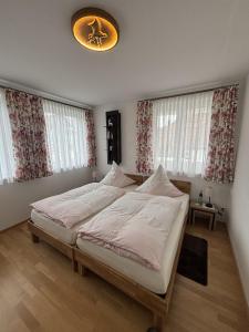 a bedroom with a large bed with white sheets at Steppacher Ferienappartements in Friedenweiler