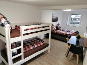 a room with two bunk beds and a table at Speedy's Gästehaus in Reimerath