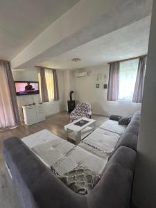 a living room with a couch and a tv at Un Rio Sana in Gornji Ribnik
