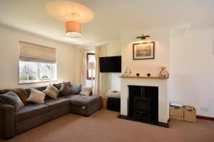 a living room with a couch and a fireplace at Family friendly house 200 meters to beach in Broad Haven