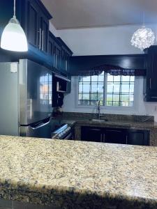 a kitchen with a granite counter top and a sink at Casa de Wen in Santa Rita +7 photos