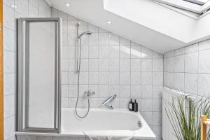 a bathroom with a shower and a bath tub at CASARINA - Alpenblick am Barmsee - FeWo Katharina in Krün +24 photos