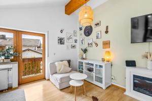 a living room with a chair and a table and a tv at CASARINA - Alpenblick am Barmsee - FeWo Katharina in Krün