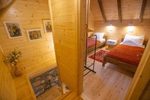 a room with two beds in a wooden cabin at Arhetip, Djedova Villa in Žabljak