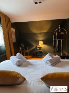 Un dormitorio con dos camas con toallas blancas encima. en Villa Aubépines, en Rochefort 18 fotos más