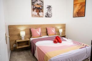 a bedroom with a bed with a red bow on it at T2 en centre ville in Cayenne