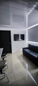 a living room with a black couch and a tv at Apartamento en el centro de Matagalpa in Matagalpa