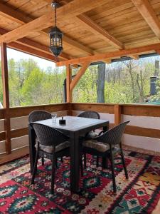 a dining room with a table and chairs on a porch at NINO Natural wood house in Visoko +59 photos