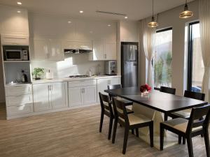 a kitchen with a table and chairs and a refrigerator at فيلا سورا sora villa 1 in Buraydah