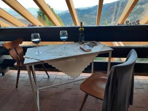 a table with two wine glasses and a bottle of wine at Seetalerhütte in Wolfsberg