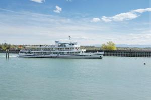 a large boat in the water next to a bridge at Ferienwohnung Konrad in Friedrichshafen +23 photos