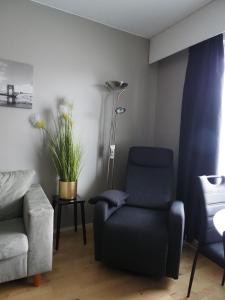 a living room with a chair and a lamp at Kompakti yksiö Sepis in Joensuu
