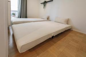 two beds in a small room with wood floors at Ferienwohnung Konrad in Friedrichshafen