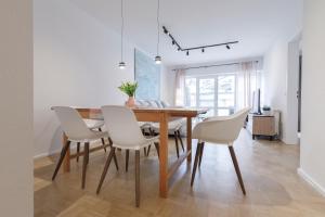 a dining room with a wooden table and white chairs at Ferienwohnung Konrad in Friedrichshafen