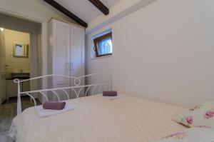 a bedroom with a white bed with purple towels on it at Ferienhaus In Posedarje Mit Großem Garten in Posedarje +16 photos