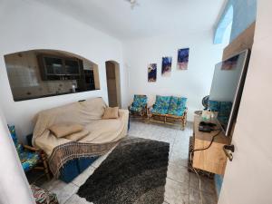 a living room with a bed and two chairs at Paz e Conforto a 8km do Aeroporto in Guarulhos