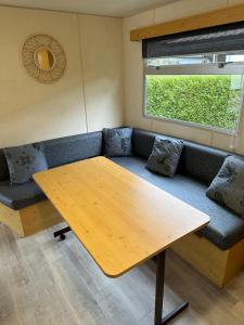 a living room with a table and a couch at Mobil-home à quelques mètres du lac d'Aiguebelette in Novalaise +4 photos