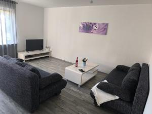 a living room with two couches and a tv at Ferienwohnung Sandner in Nüdlingen
