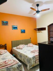 a bedroom with two beds and a ceiling fan at Hotel Aparecida do Norte in Aparecida +22 photos