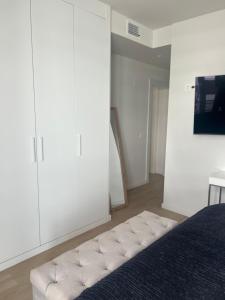 a white bedroom with a bed and white cabinets at Habitación En Casa de Familia Room in family home Solamente para personas tranquilas Only quiet people in Marbella