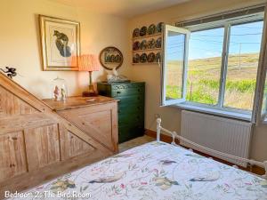 a bedroom with a bed with a dresser and a window at BillWatch Cottage in Southwell