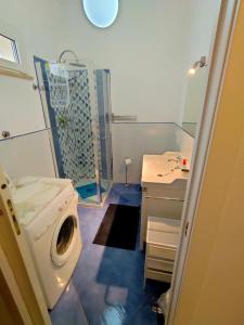 a bathroom with a washing machine and a sink at Villa dell'Ancora in Capoliveri