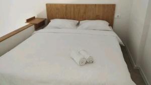 a bed with two white shoes sitting on it at Apartman Herceg in Mostar