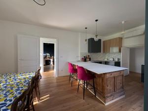 a kitchen with a counter and chairs in a room at Maison 1880 in Annonay +39 photos