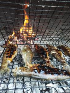 a bunch of food cooking on a grill at Apartman Iman in Bihać
