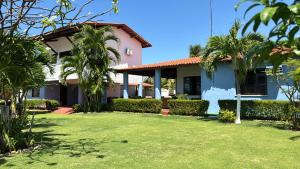 a house with a lawn in front of it at Splendide villa à morro branco vue sur mer in Beberibe