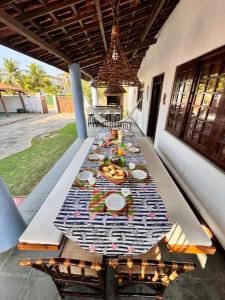 a long table with plates of food on it at Splendide villa à morro branco vue sur mer in Beberibe