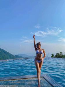 a woman in a bikini standing on the edge of a pool at BUNGALOW 2 -phòng săn mây vạn người mê in Tam Ðảo
