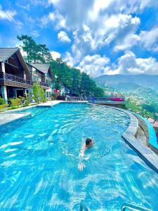 a person swimming in a large swimming pool at BUNGALOW 2 -phòng săn mây vạn người mê in Tam Ðảo