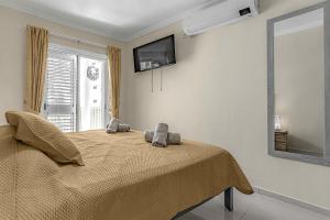 Un dormitorio con una cama con dos animales de peluche encima. en La Perla Beach Vibes, en Puerto de Santiago 42 fotos más