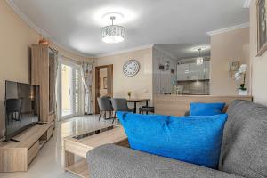 Una sala de estar con un sofá y una cocina. en La Perla Beach Vibes, en Puerto de Santiago