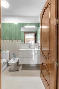 Un baño con lavabo, inodoro y espejo. en La Perla Beach Vibes, en Puerto de Santiago