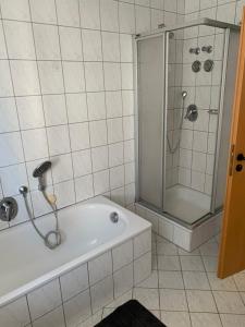 un bagno con doccia e vasca da bagno di Preiswerte Ferienwohnung a Neukirchen Altre 14 foto